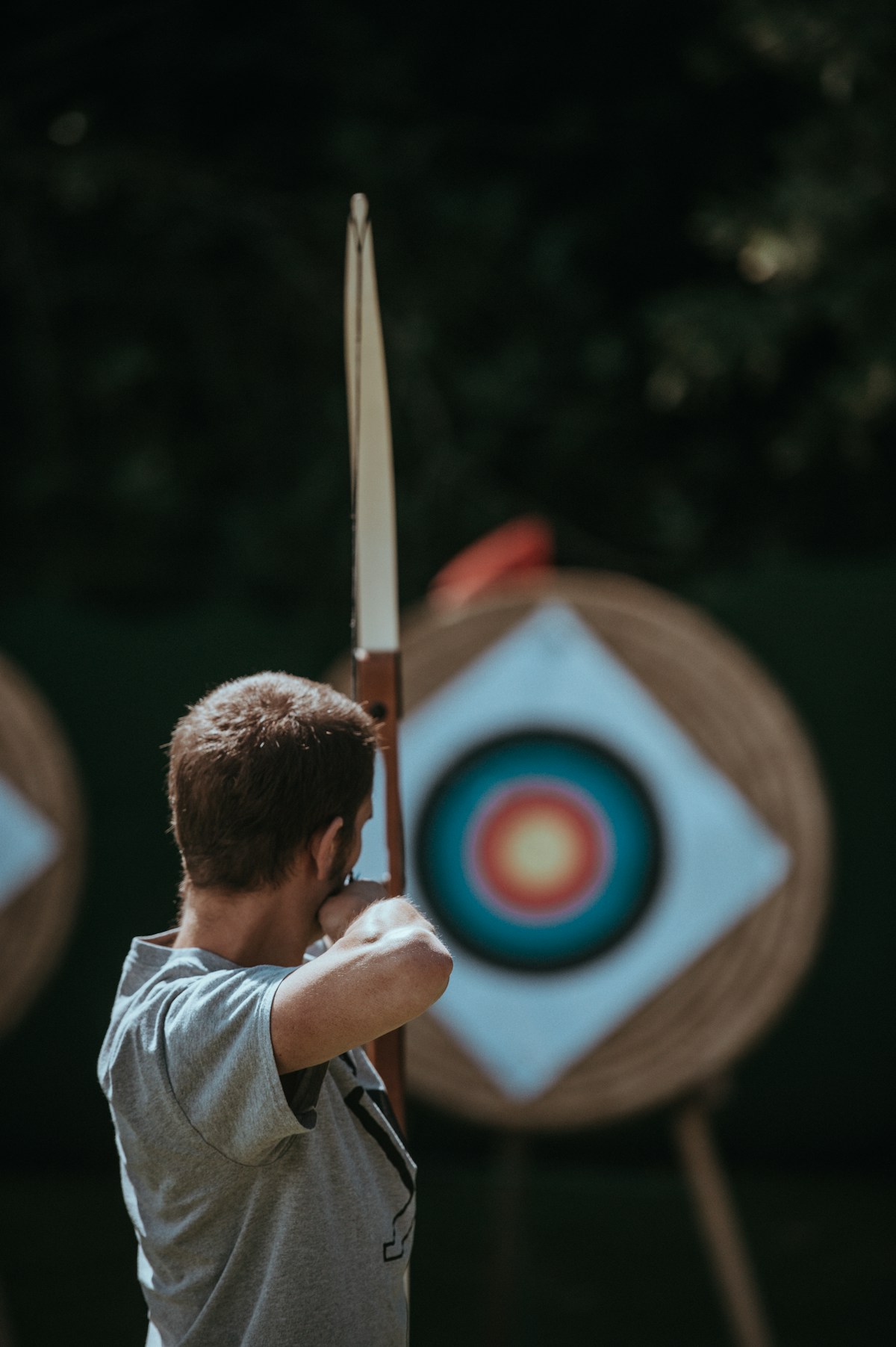Archer drawing bow at outdoor range - Unsplash