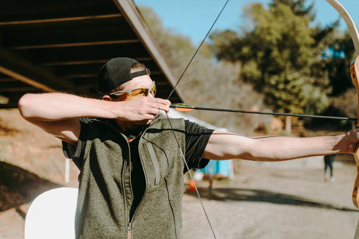 Archer aiming at outdoor targets demonstrating proper bow stabilizer balance