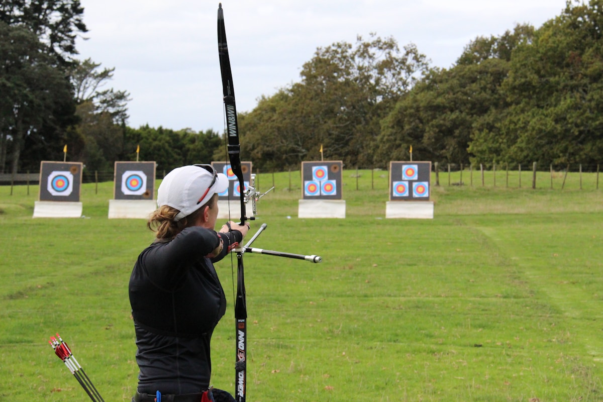 Archer practicing in open field with arrow leaving bow at high speed