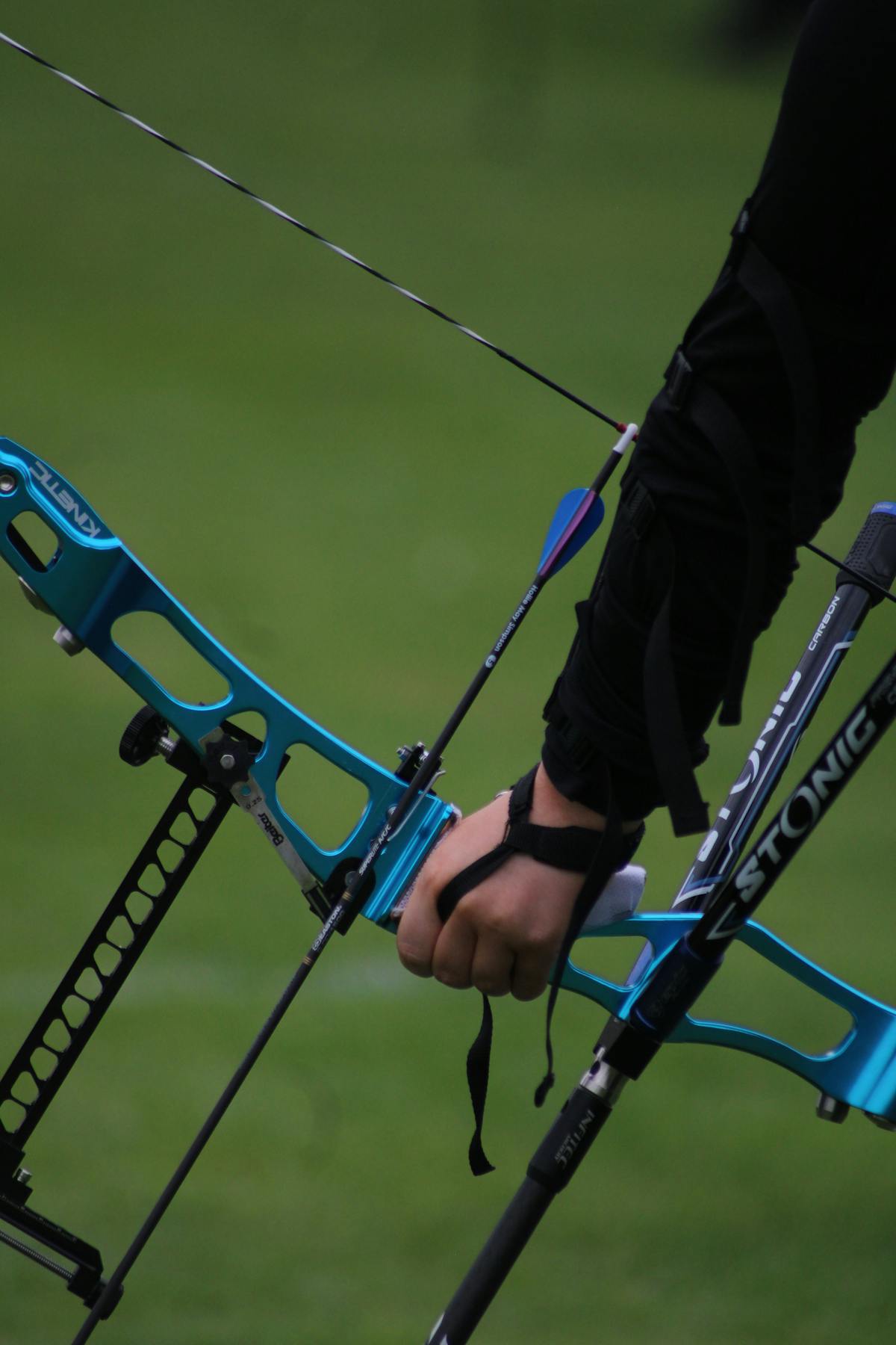 Close-up detail of archer's hand on compound bow grip during hunting arrow practice