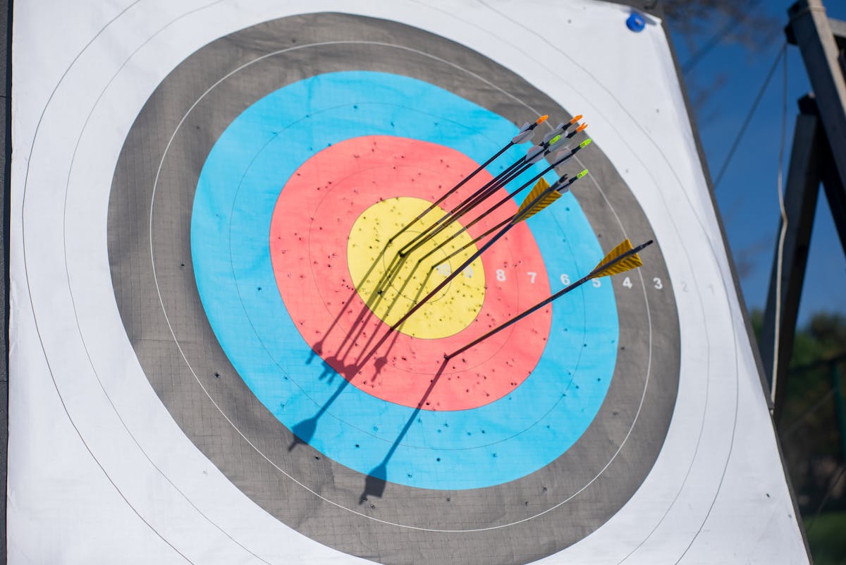 Archery target with arrows grouped in bullseye showing accurate bow sight settings