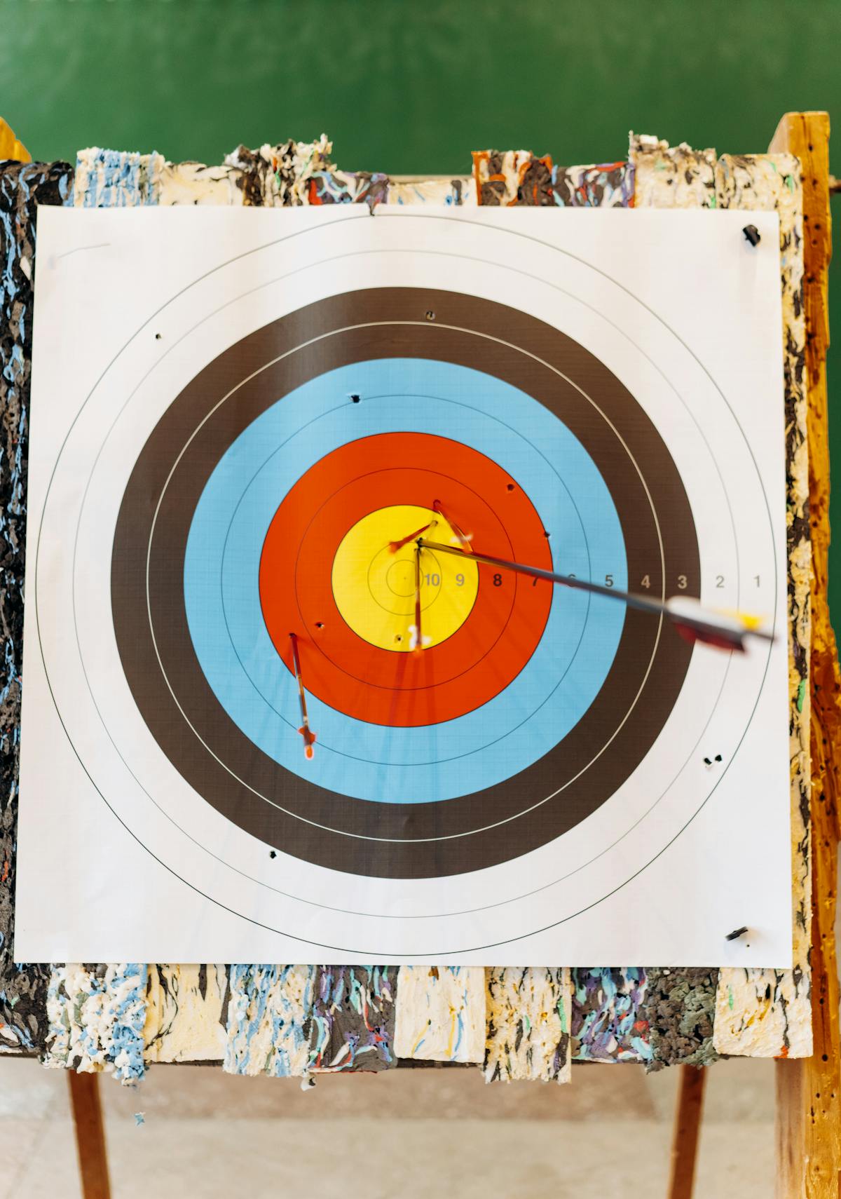 Close-up of arrow hitting bullseye on archery target after sight calibration