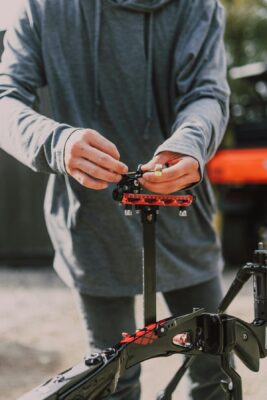Archer adjusting bow sight on compound bow for precise windage and elevation settings