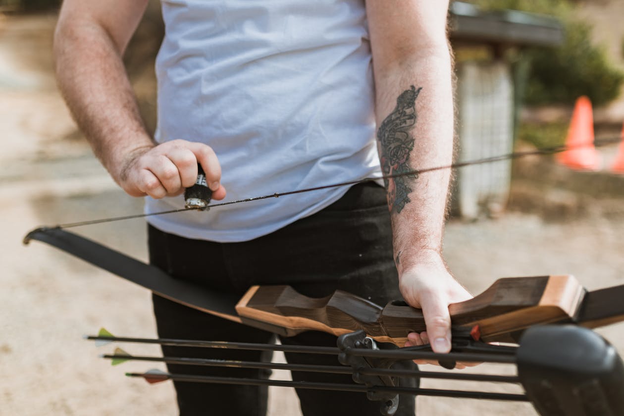 Archer applying wax to a bowstring during spring compound bow maintenance