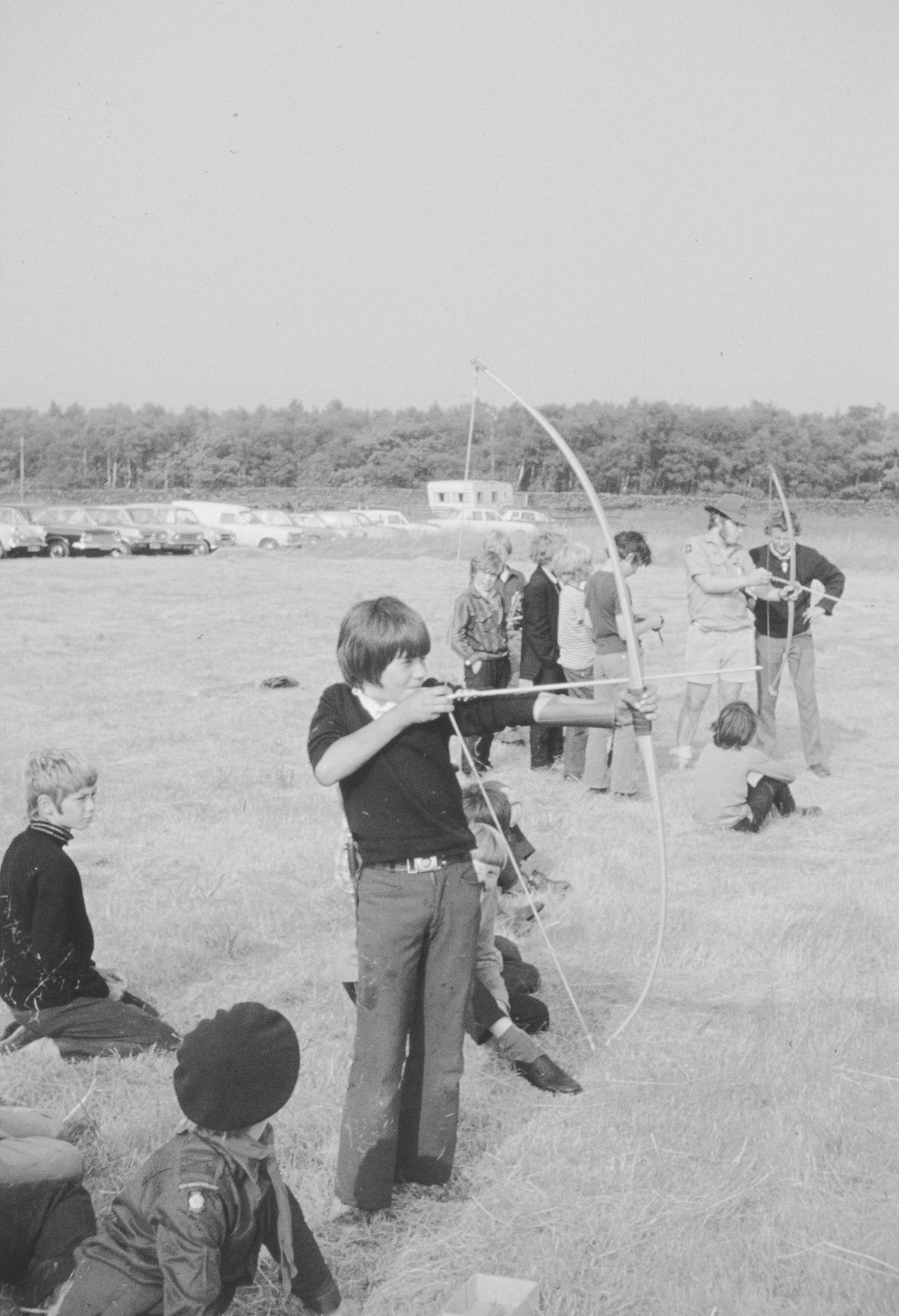 Youth archers practicing outdoors at school archery program field day