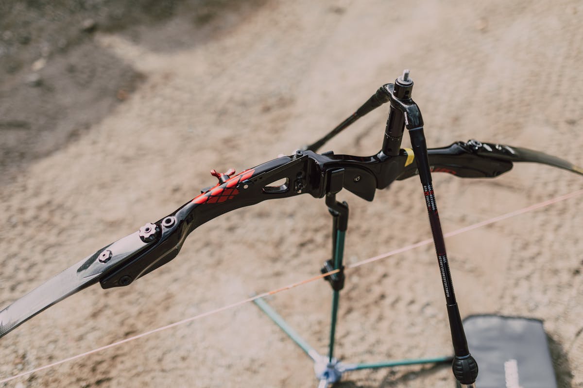 Modern compound bow resting on a stand at an outdoor archery range ready for tuning tests