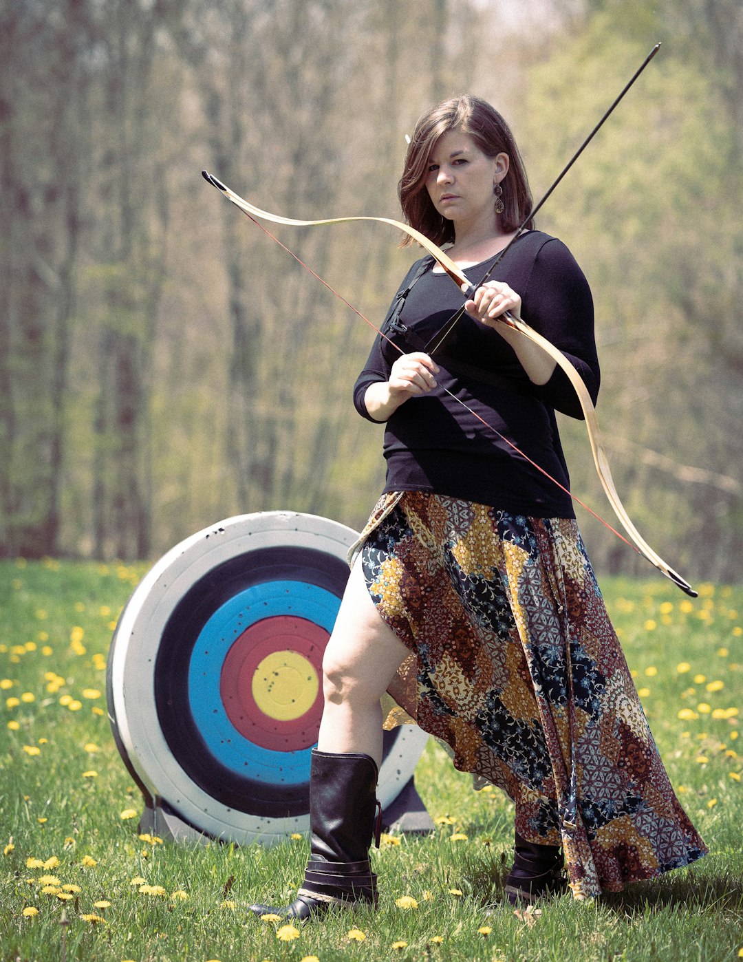 Female archer drawing a bow with stabilizer attached for balanced aiming