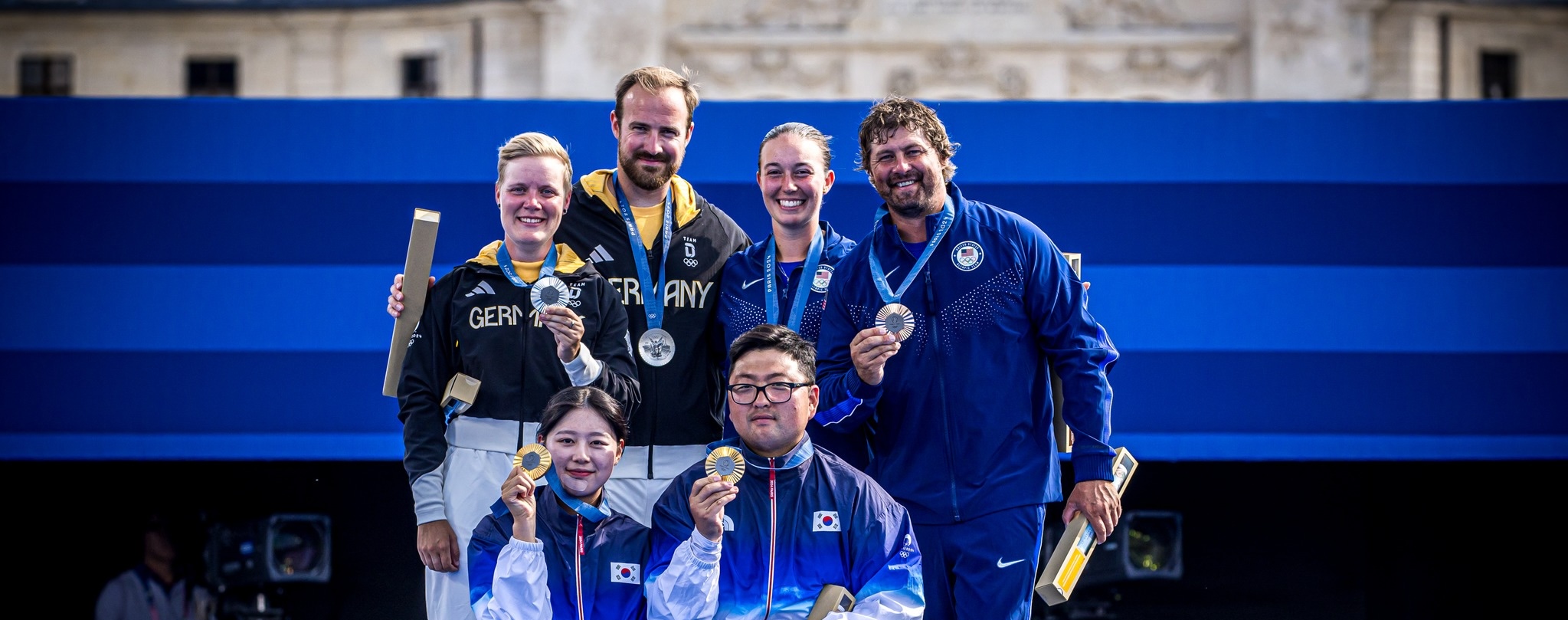 Olympic archery competition showing elite archers with optimized draw length