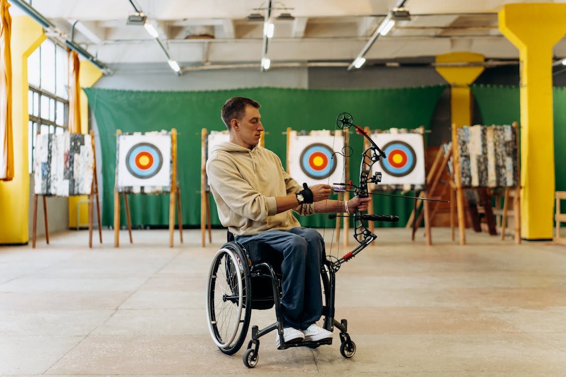 Para archery athlete in wheelchair practicing adaptive archery with compound bow