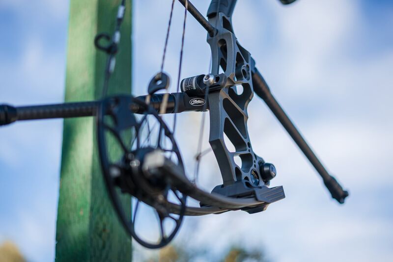 Archer at full draw with compound bow stabilizer