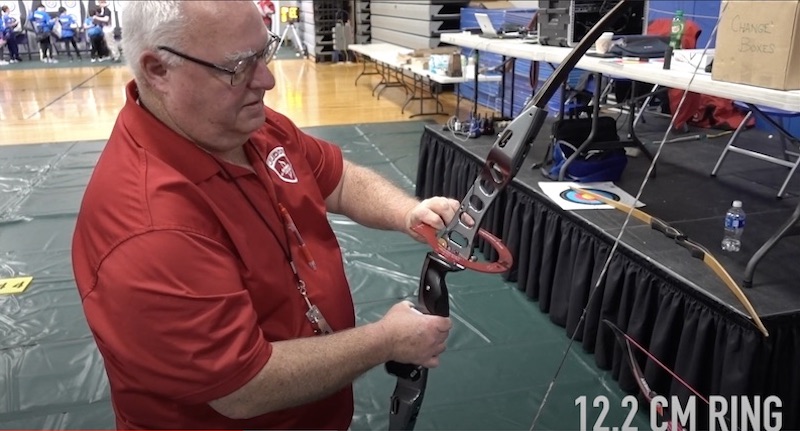 Archer checking recurve bow draw weight and brace height
