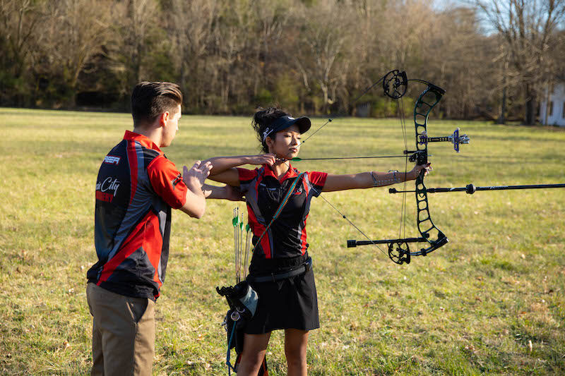 Archer shooting target compound bow at range
