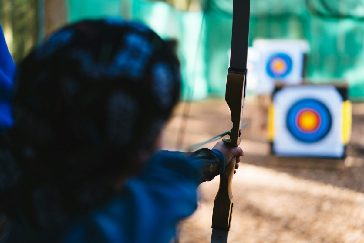 Recurve archer at full draw aiming at outdoor target during European archery championships