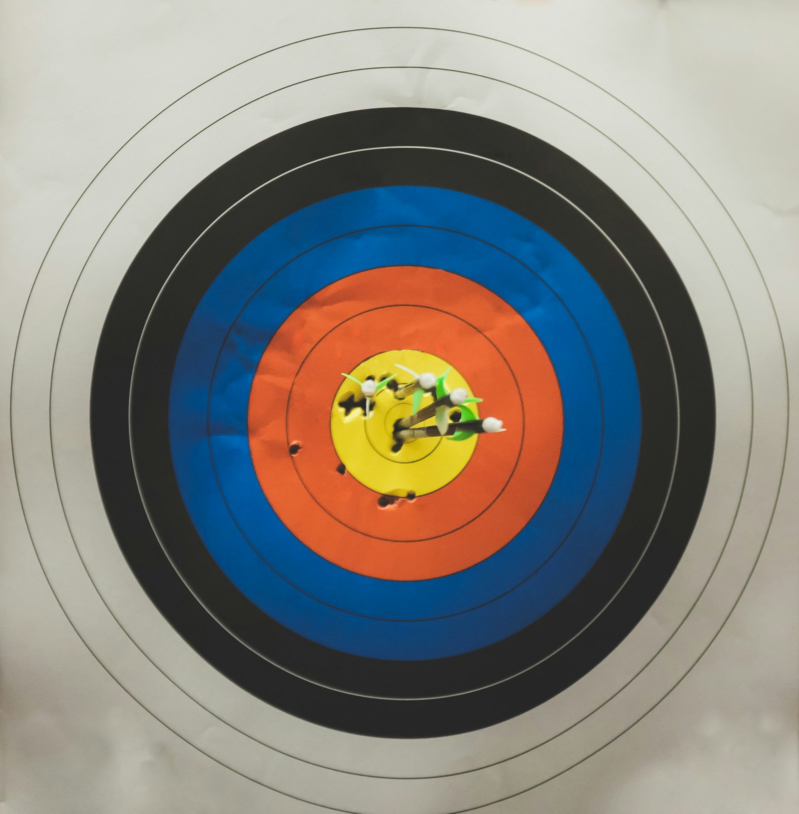 Arrows clustered in archery target bullseye after compound bow tuning session