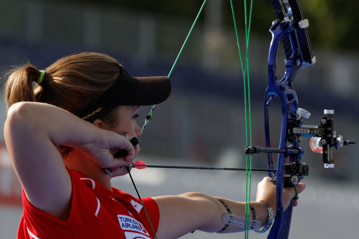 Compound archer aiming with multi-pin slider bow sight in competition