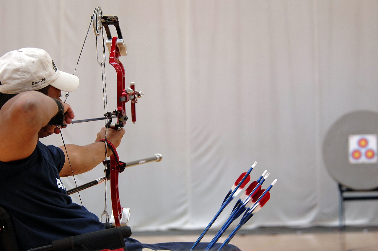compound bow being tuned with bow press in archery shop