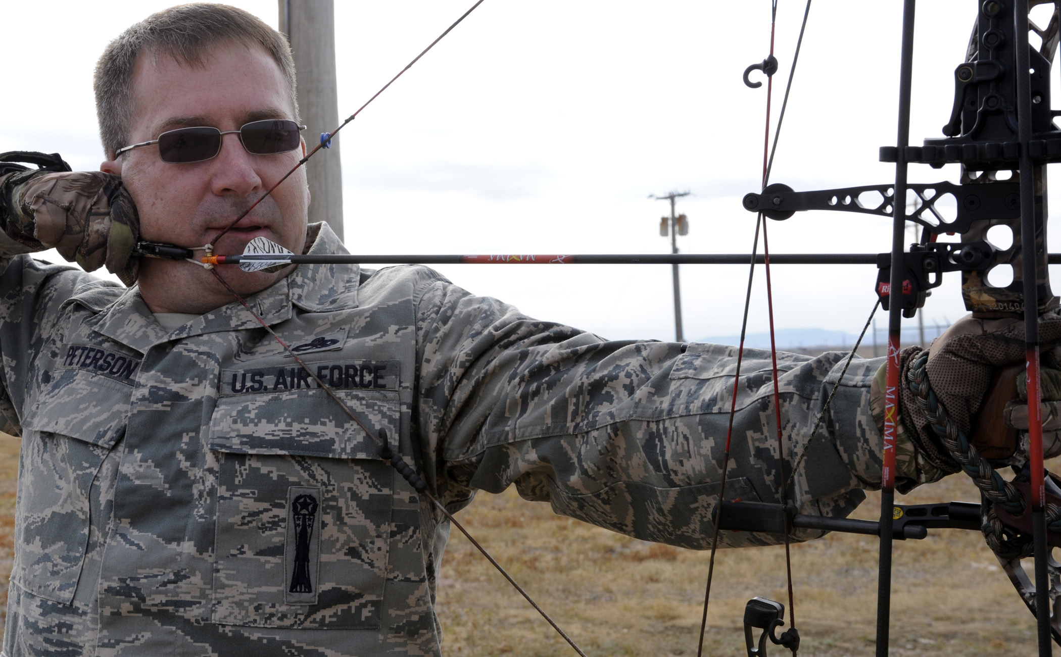archer aiming compound bow for hunting