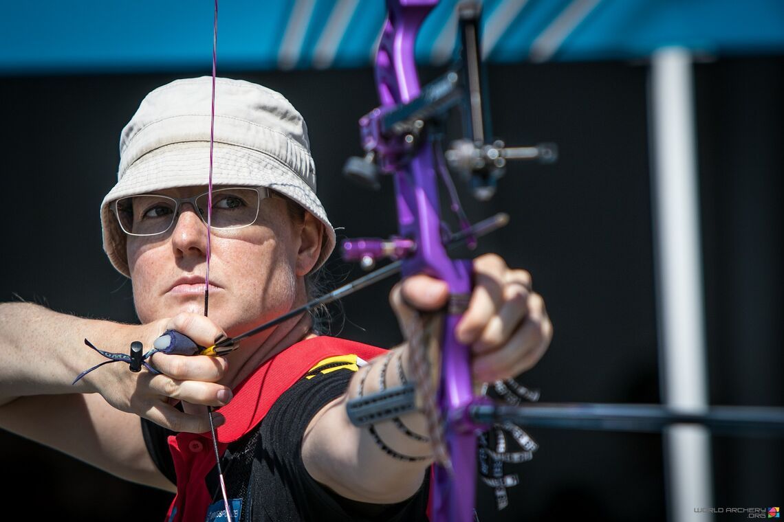 Compound bow archer aiming with both eyes open to find dominant eye in archery