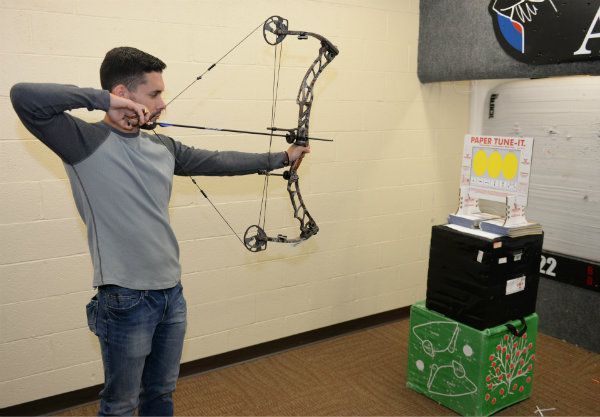 Archer paper tuning a compound bow at indoor station