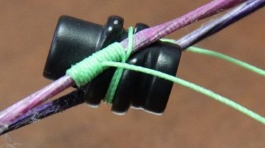 Peep sight serving wrap technique with green serving thread on a bow string