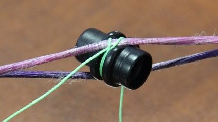 Close up of a 3/16 inch peep sight installed in a compound bow string for hunting