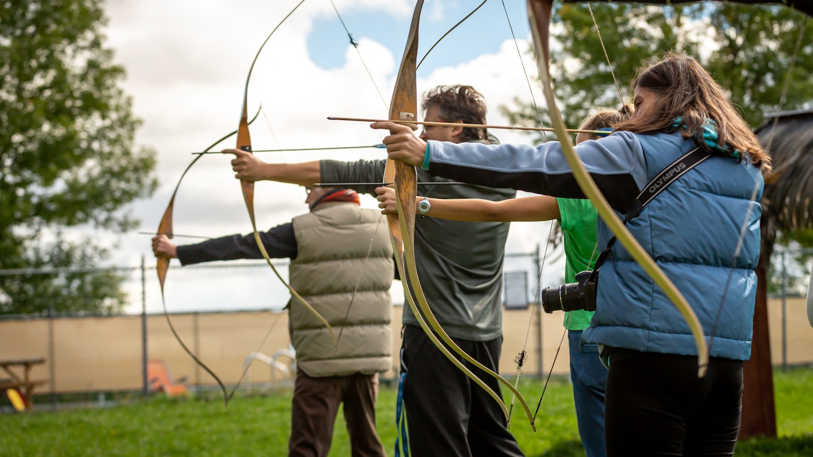 Group of recurve archers practicing form at outdoor archery field together