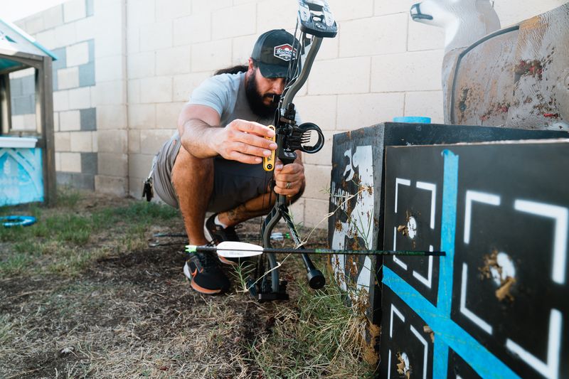 Archer looking through peep sight aligned with compound bow sight pins