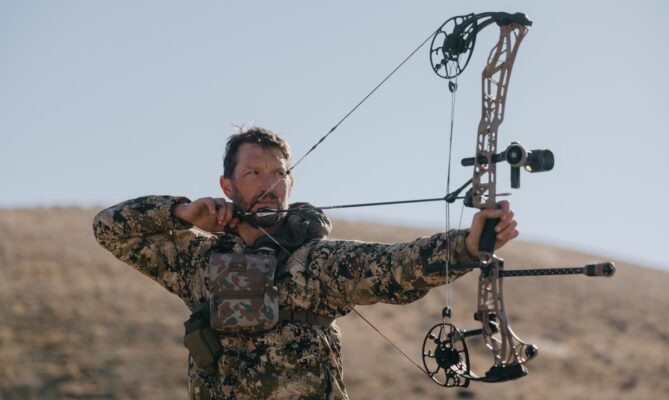 Bowhunter at full draw using an archery release aid on a compound bow