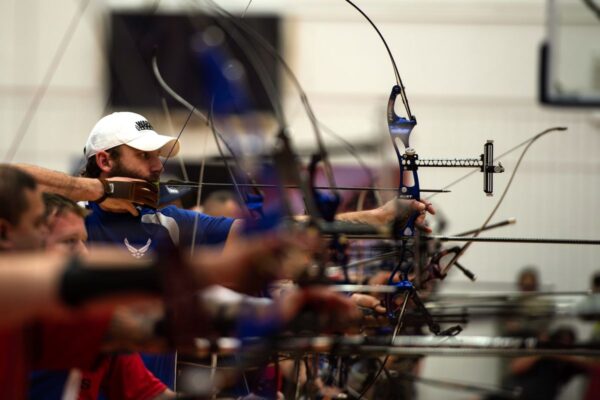 Compound bow archers at full draw on the line during a major archery competition