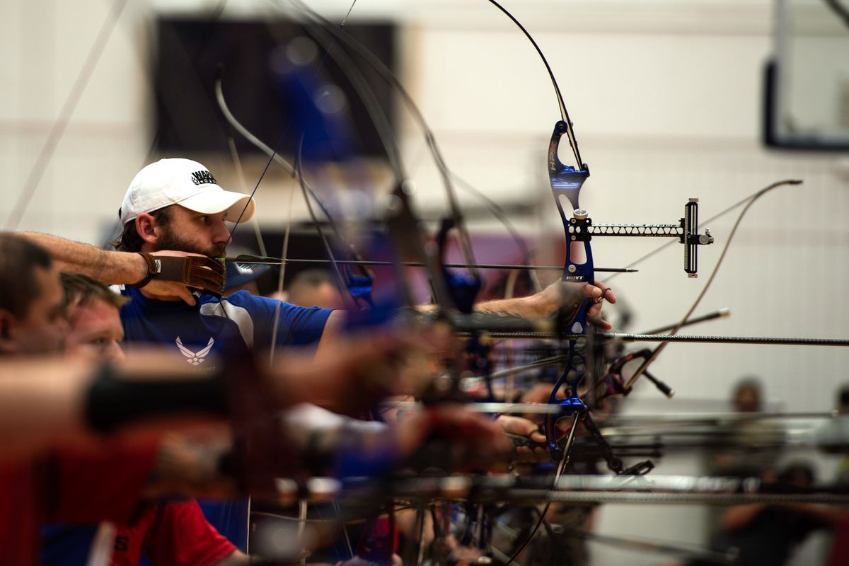 Compound bow archers at full draw on the line during a major archery competition
