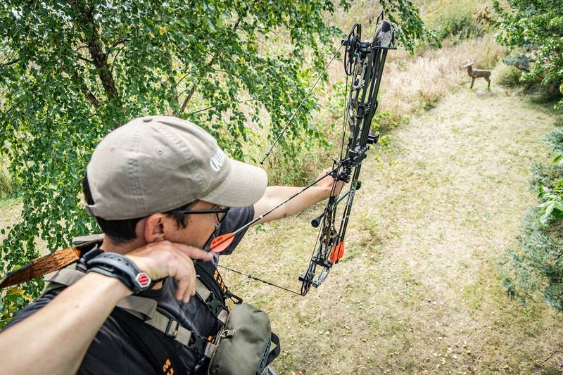 Bowhunter at full draw aiming at deer target with high arrow FOC setup