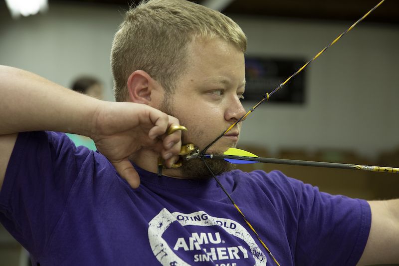 Archer drawing a compound bow with an arrow nocked to avoid a dry fire