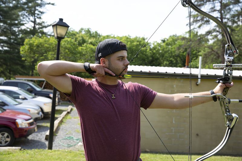 Archer at full draw using a release aid, demonstrating controlled draw and let-down