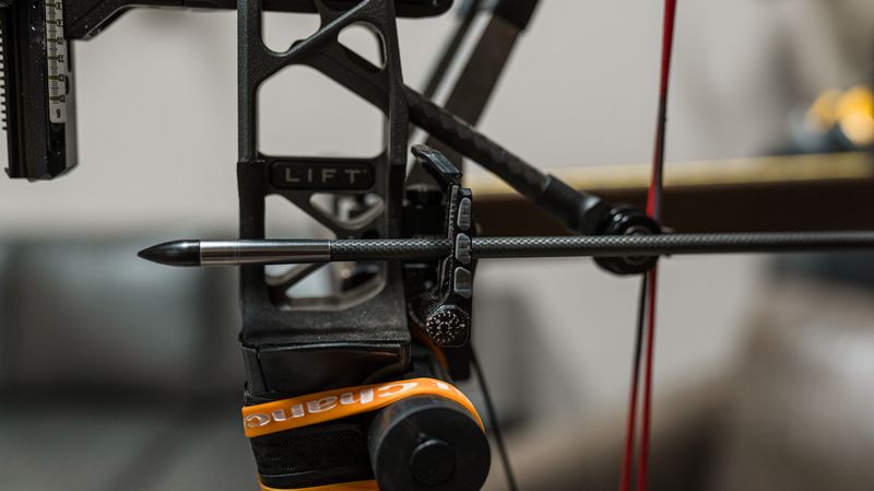 Arrow on the rest of a compound bow being adjusted during bareshaft tuning