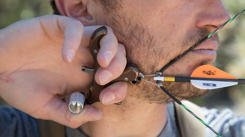 Archer at full draw with a thumb release illustrating proper anchor for bareshaft tuning