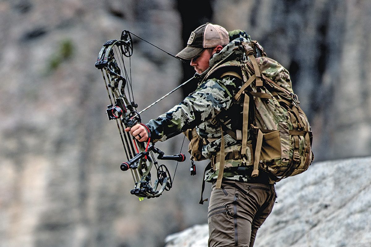 bow quiver types in action: bowhunter at full draw with bow-mounted quiver