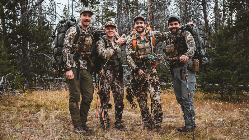 Bowhunters with compound bows after a backcountry hunt