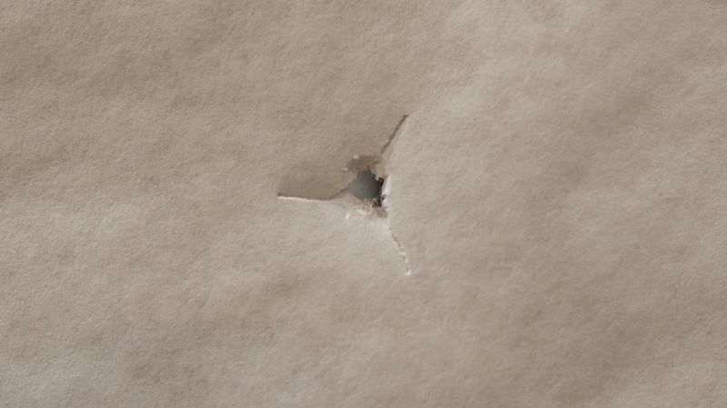 Bullet hole through paper confirming initial paper tune before bareshaft tuning