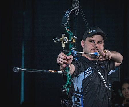 Archer at full draw on a compound bow with synchronized cams in the cam timing position