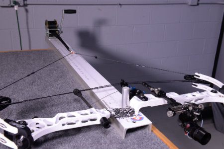 Compound bow mounted on a draw board to verify cam timing