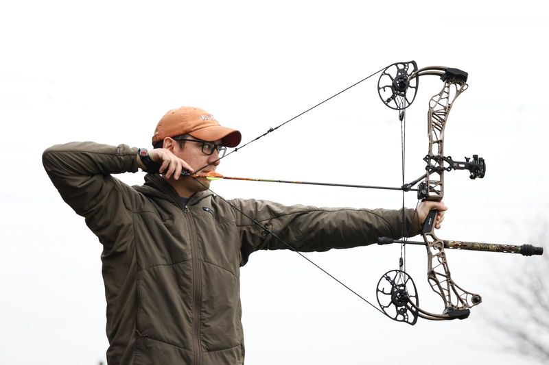 Archer at full draw with compound bow showing how compound bow works