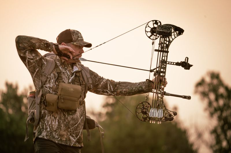 Bowhunter at full draw with compound bow showing proper draw length and form