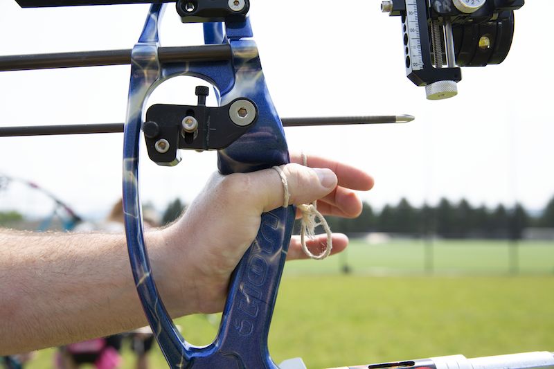 Compound bow grip showing correct hand placement on a blue riser