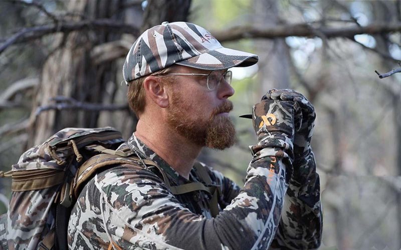 Hunter using cow elk calling tactics during a DIY archery hunt