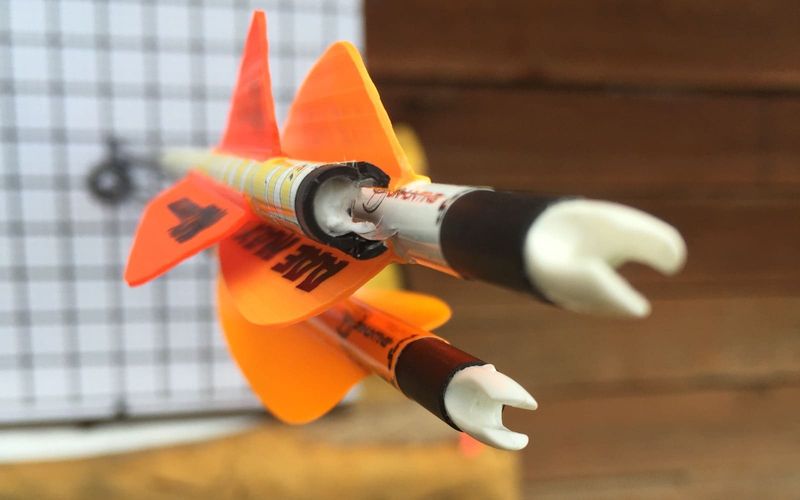 Close-up of helical fletching vanes on a hunting arrow shaft showing the spiral angle