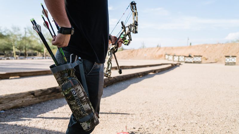 hip quiver on target archer with compound bow at outdoor range
