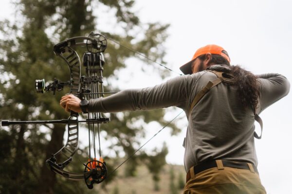 Archer at full draw demonstrating how to sight in a compound bow
