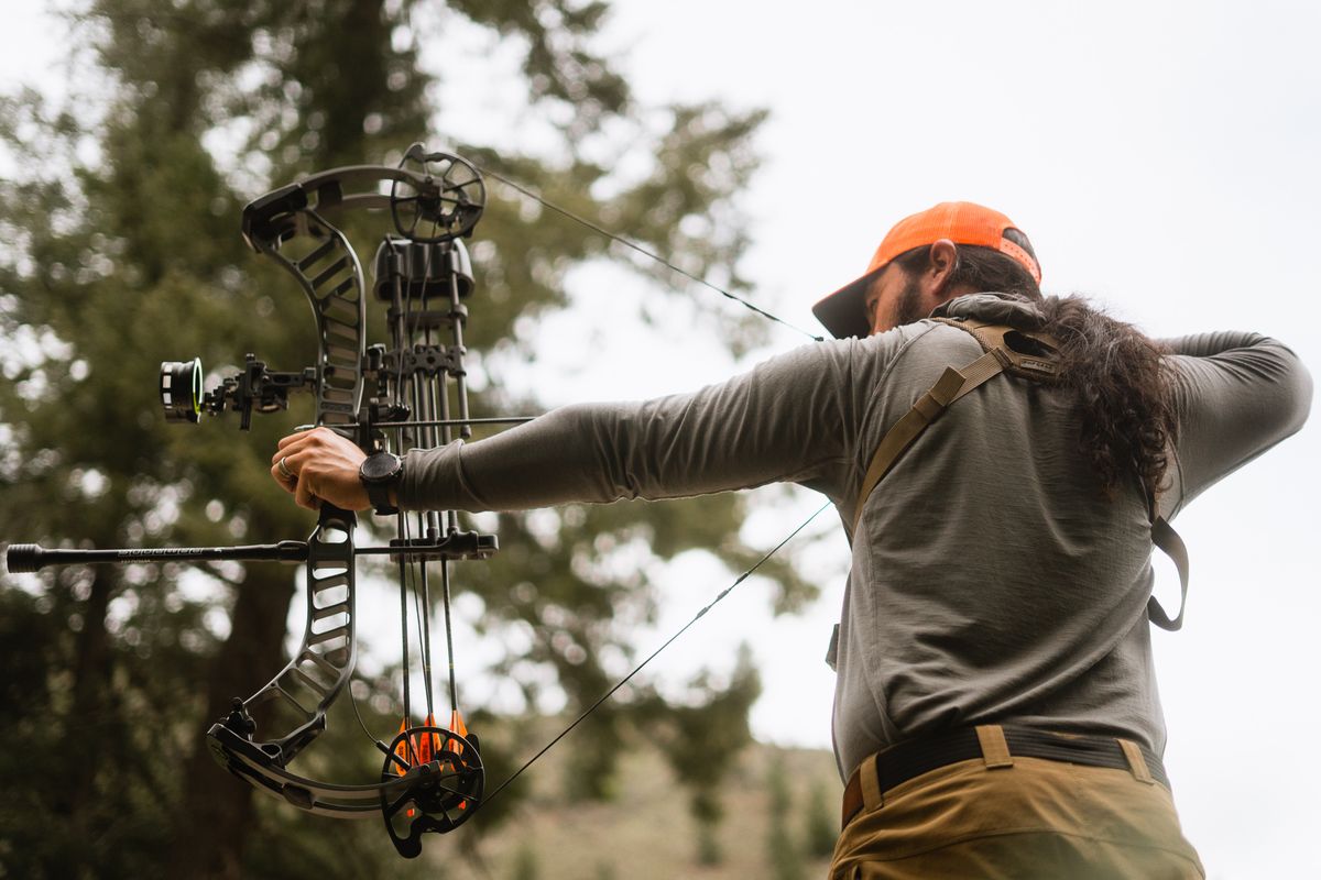 Archer at full draw demonstrating how to sight in a compound bow