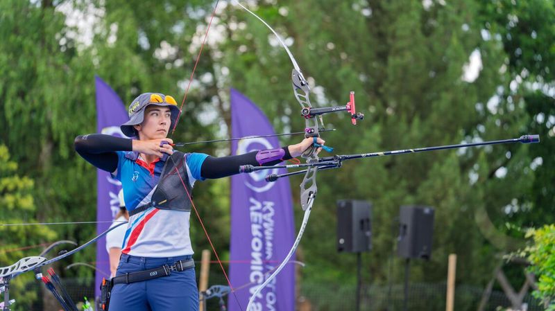 Recurve archer at full draw showing arrow spine flex during release