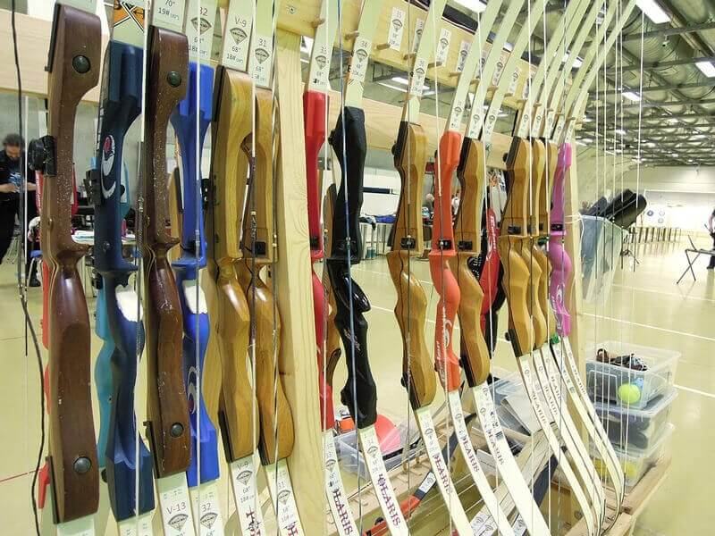Rack of takedown recurve bow risers and limbs at a tournament